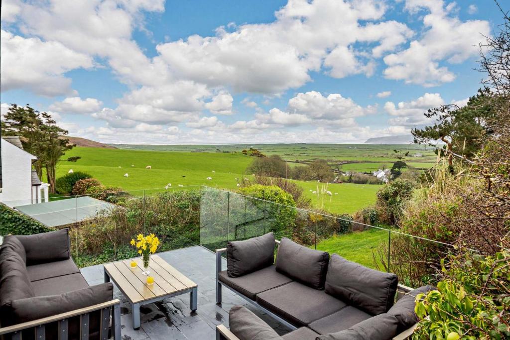 patio con divani e tavolo con vista di Tyn Y Mur Cottage a Llangian