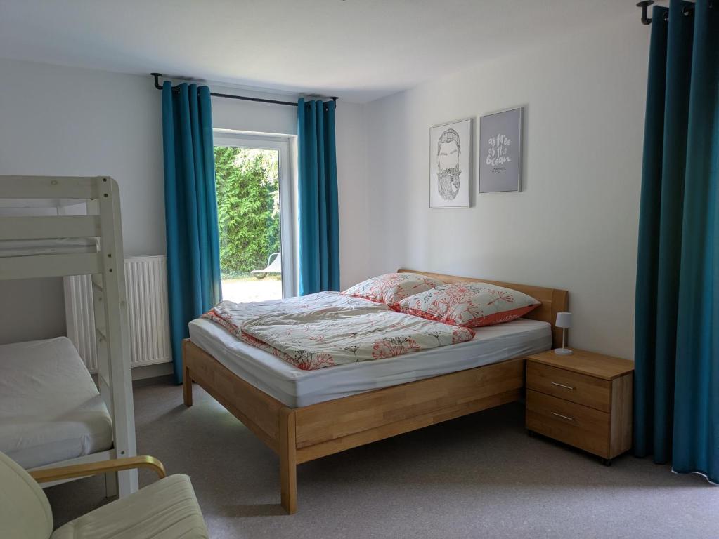 a bedroom with a bed with blue curtains and a window at Ferienwohnung Familie Baus in Hammelburg