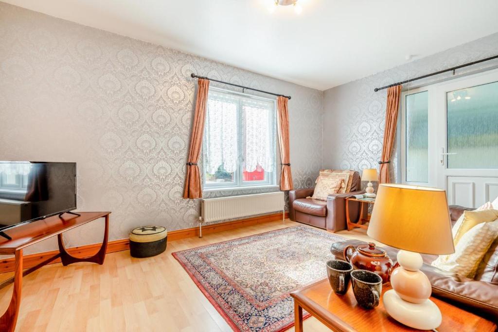 una sala de estar con un sofá y una mesa en Tremill Lodge, en Wadebridge