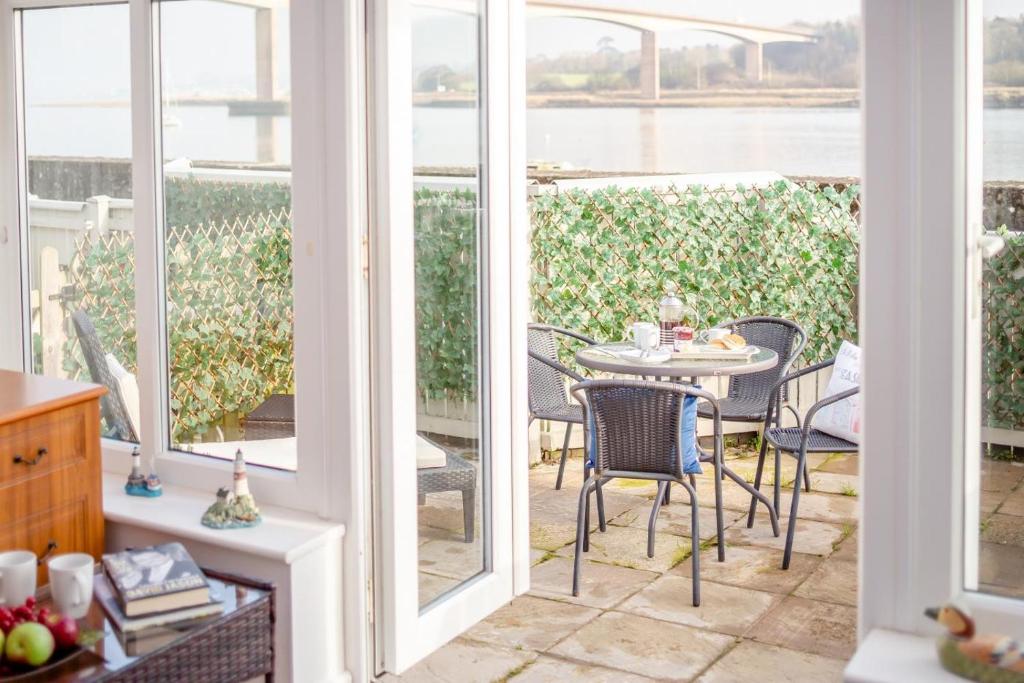 ein Esszimmer mit einem Tisch und Stühlen auf einer Terrasse in der Unterkunft Mariners Rest in Bideford