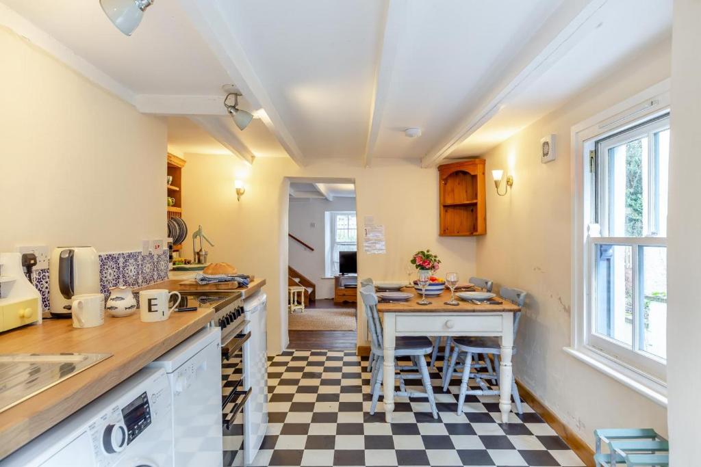 a kitchen with a counter and a table and chairs at West Creek Cottage in Little Petherick