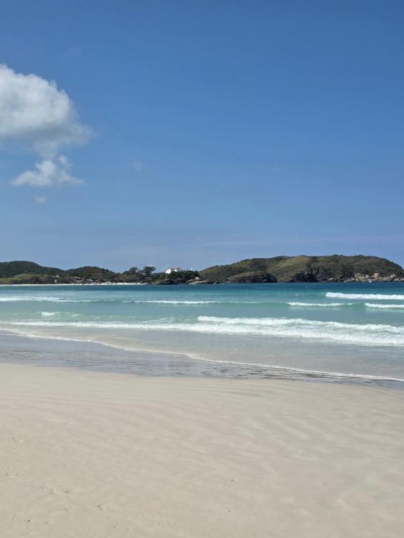 ein Sandstrand mit dem Meer im Hintergrund in der Unterkunft Apto no coração da Praia do Forte em Cabo Frio in Cabo Frio