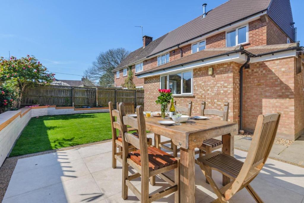 un patio avec une table et des chaises en bois dans l'établissement Lavender Cottage - Brockenhurst, à Brockenhurst