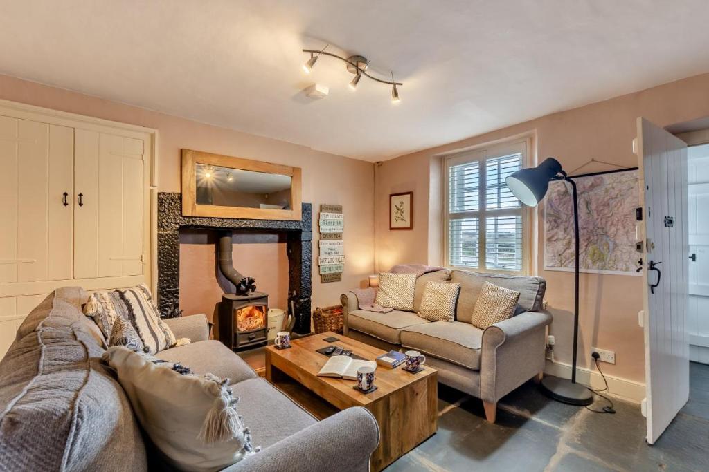 Una sala de estar con dos sofás y una chimenea. en Low Dog Kennel, en Cartmel