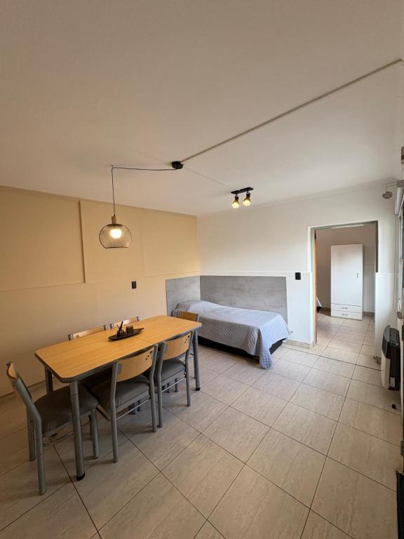 a living room with a table and a bed at Complejo Sucre I in San Luis