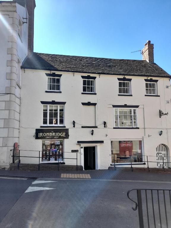 a white building with a sign for a store at Ironbridge town apartment in Ironbridge