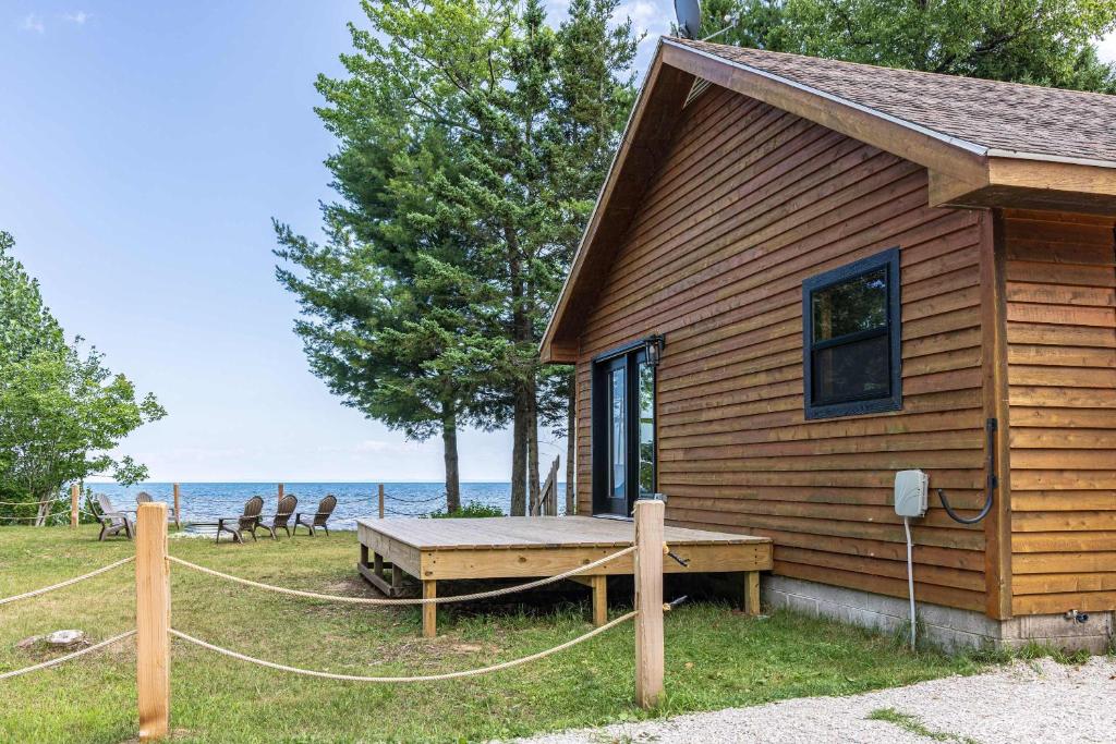 a log cabin with a porch and a bench at Adventure & Relaxation by Lake Superior in Paradise