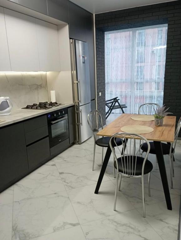 a kitchen with a table and chairs in a kitchen at ЖК Dream Town, Lutsk in Lutsk