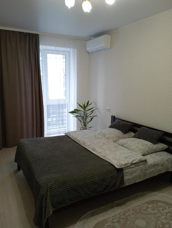 ルツカイにあるЖК Dream Town, Lutskの大きなベッドと窓のある寝室