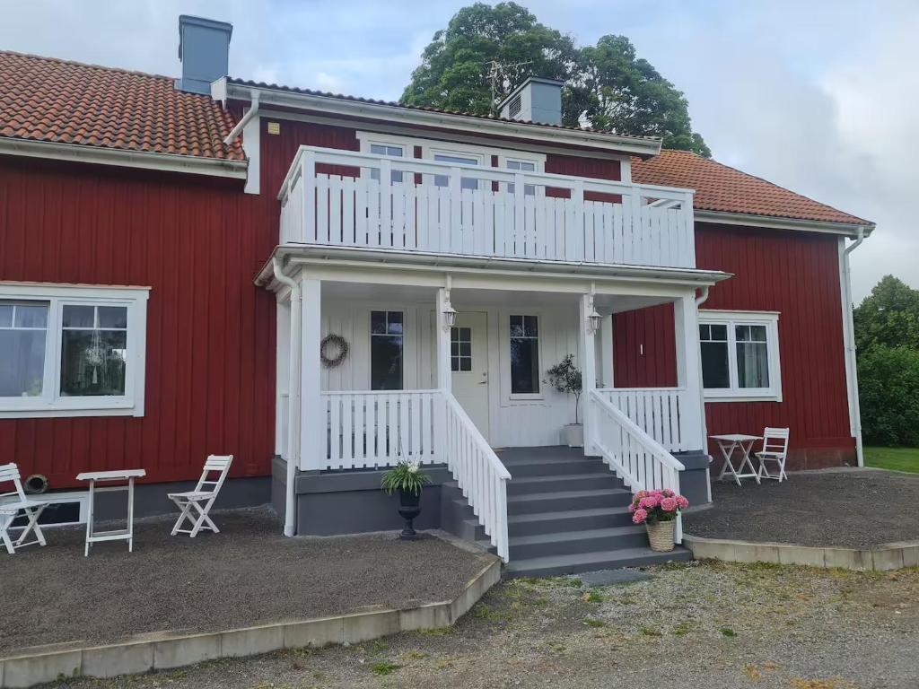 a red house with a white porch and stairs at Hus i Småland in Eksjö