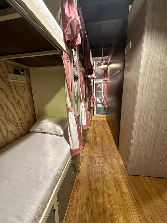 a room with two bunk beds and a wooden floor at Lucky beds pg and hostel in Mumbai