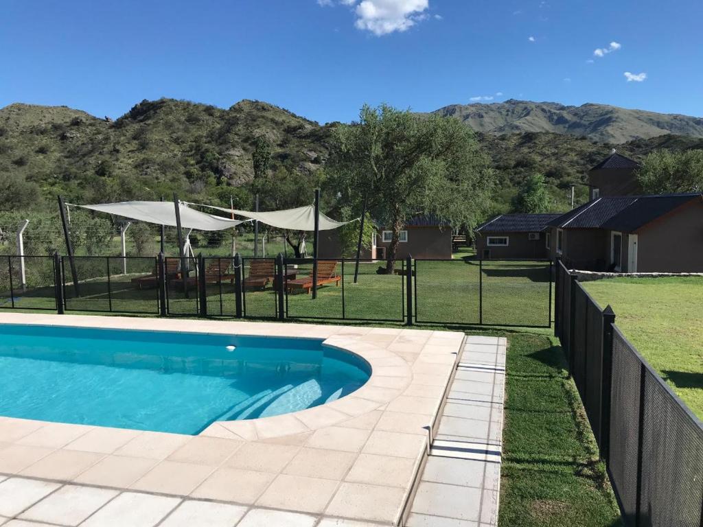 una piscina in un cortile con una recinzione di Cabañas La Delfina para 4 personas Potrero de los Funes a Potrero de los Funes