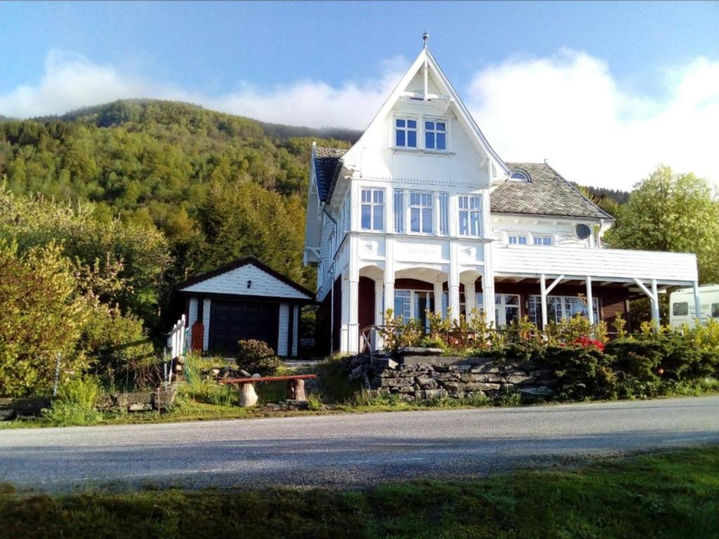 a large white house on the side of a road at Gemütliche Ferienwohnung am Fjord 