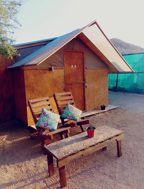 a couple of benches sitting in front of a building at Hostel con huerta en la montaña in San José del Cabo
