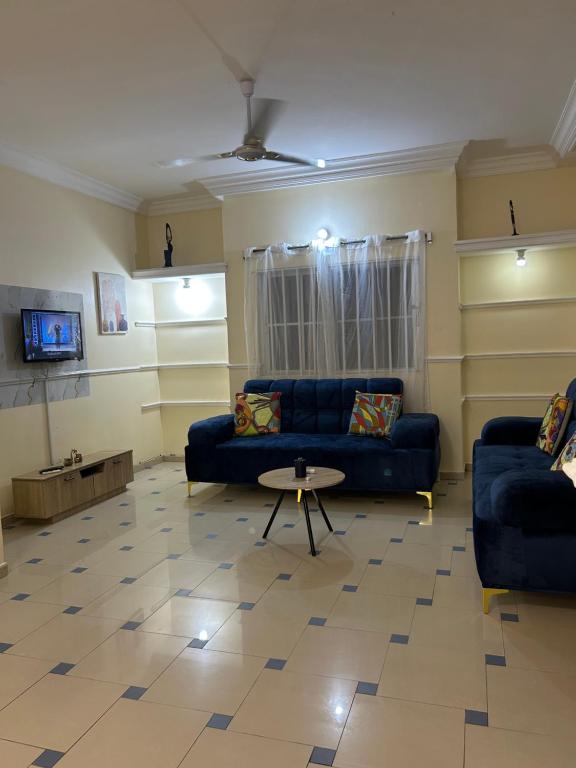 a living room with a blue couch and a table at Al appartement in Cotonou