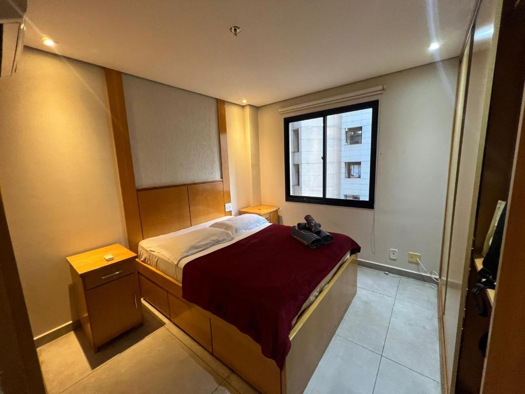 a small bedroom with a bed and a window at Hotel Flat Moema UH 715 in Sao Paulo
