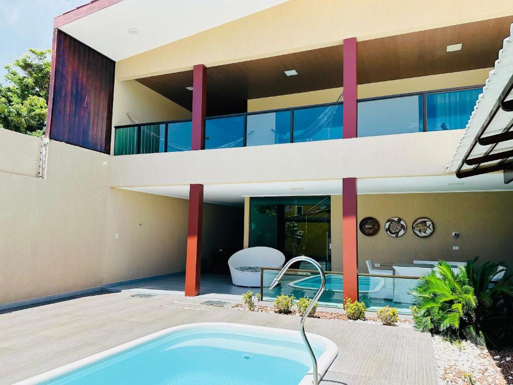 eine Außenansicht eines Hauses mit Swimmingpool in der Unterkunft Casa luxo beira mar 5 qtos e piscina in Tamandaré