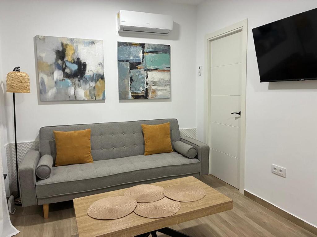 a living room with a couch and a table at Nuestro lugar feliz Apartamento Barbate - Patio ducha exterior in Barbate