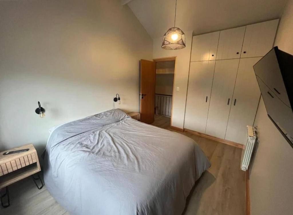 une chambre avec un lit blanc et un bureau dans l'établissement Complejo Pradera Centro, à San Martín de los Andes