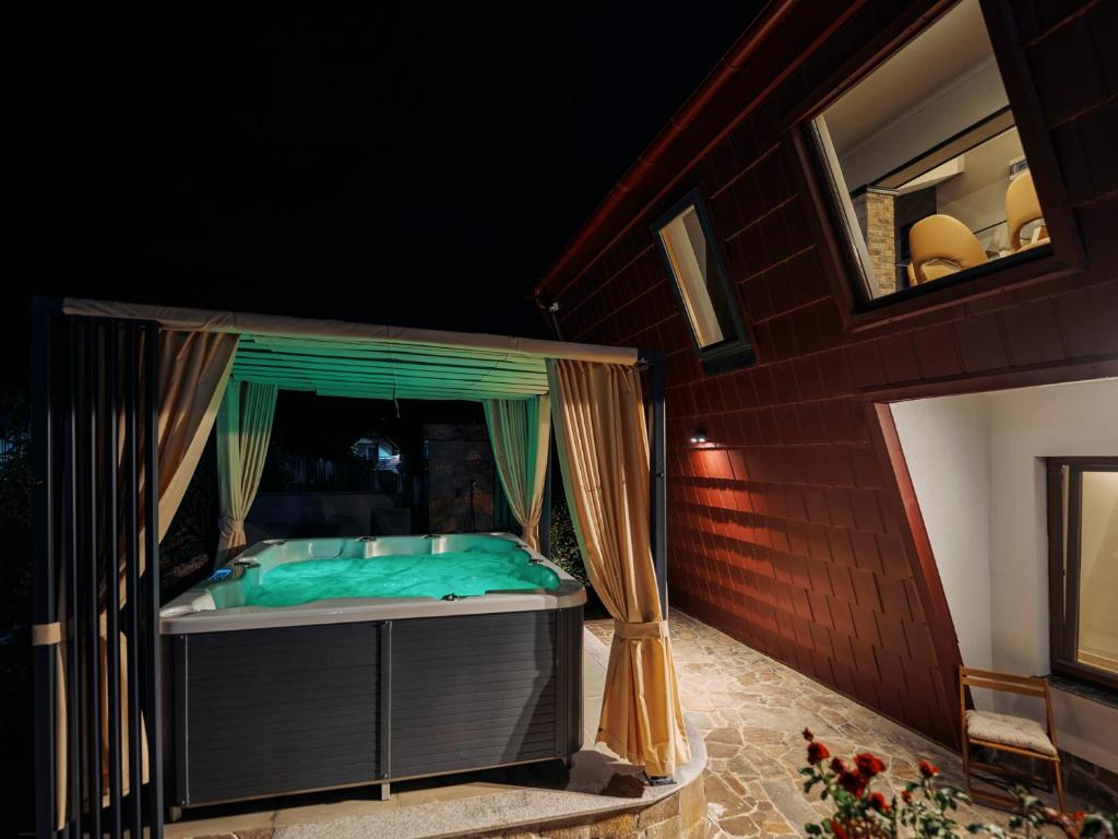 a bed on a porch of a house at night at Bungalou Ikabane in Văratec