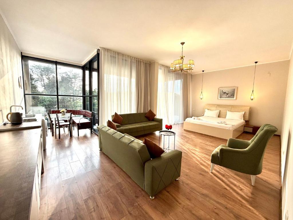 a living room with a couch and a bed and a table at Sun Line Hotel Kobuleti in Kobuleti