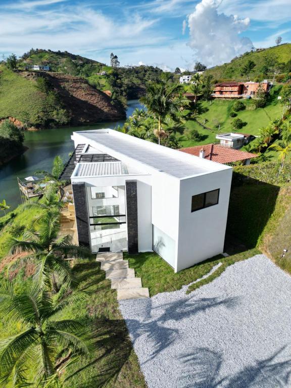 an aerial view of a white house with a river at Finca Las palmas Guatape in Guatapé