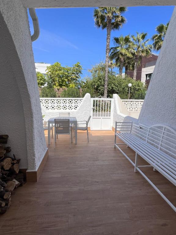 a balcony with two white benches and a table at Ideal modern bungalow MA1 in Torrevieja