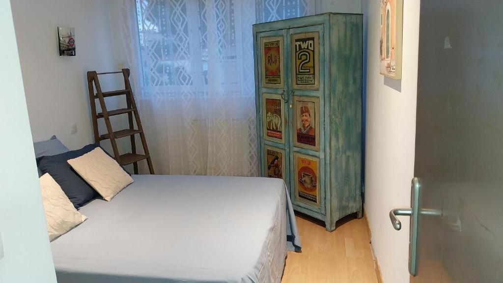 a bedroom with a bed and a green cabinet at Superbe appartement avec piscine et parking in Fréjus
