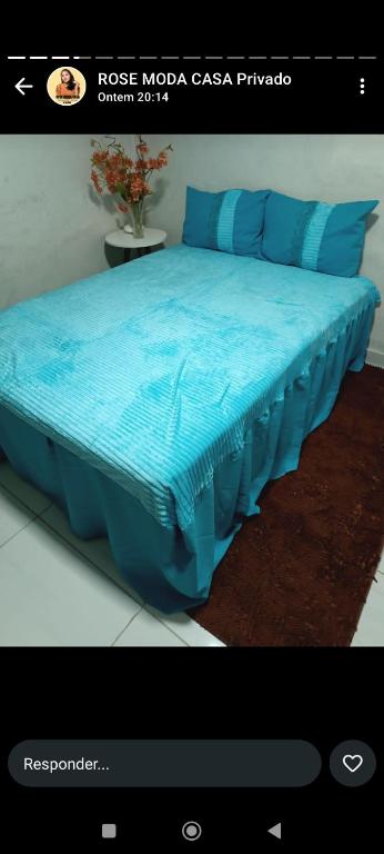 a webpage of a bed with blue sheets on it at Hospedagem Nininha in Ananindeua