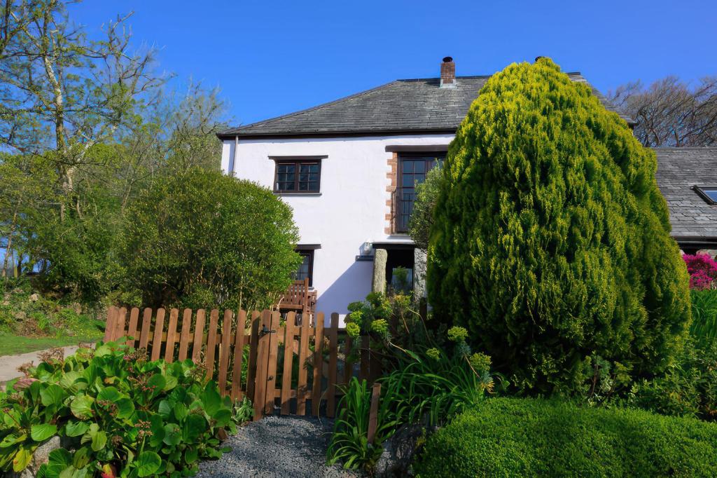 a house with a fence and a large tree at Beech Cottage in Launceston