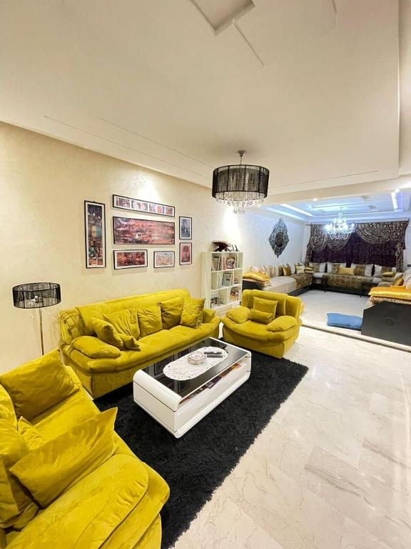 a living room with yellow couches and a table at Diamond Residence Fes in Fez