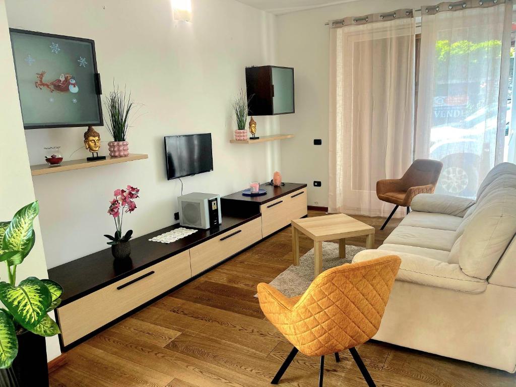Una sala de estar con un sofá y un televisor. en Dreamy garda house, en Nago