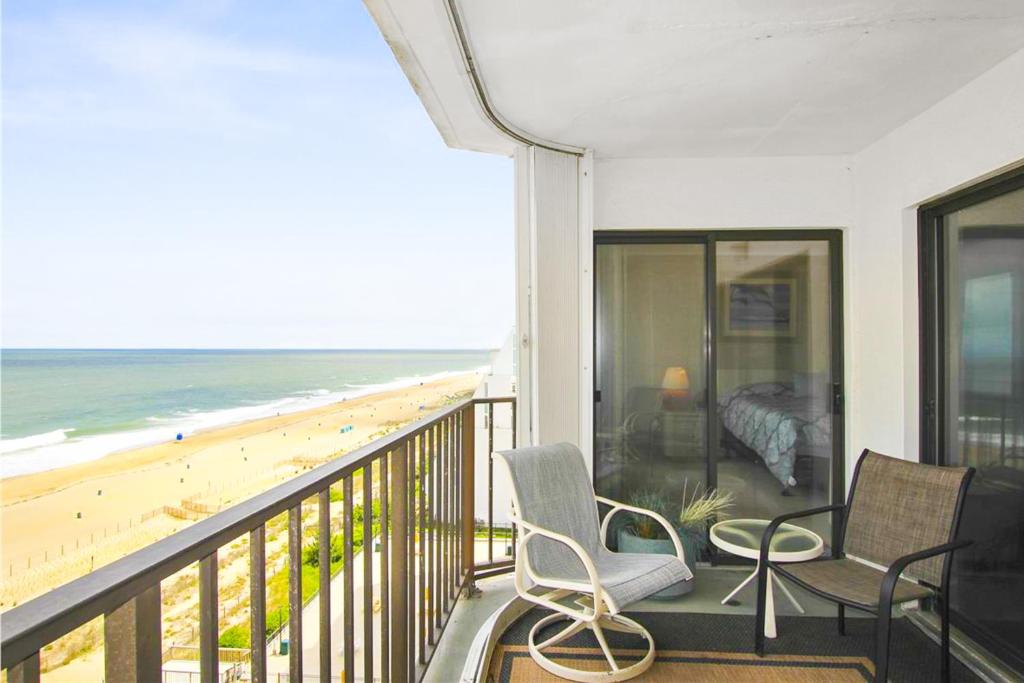 a balcony with two chairs and a bed and the beach at Plaza 909 in Ocean City