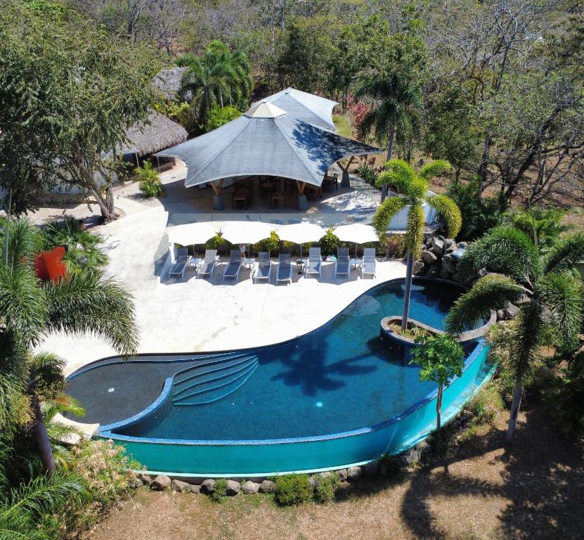 an overhead view of a swimming pool with chairs and a tent at Mikado Natural Lodge in Playa Avellana