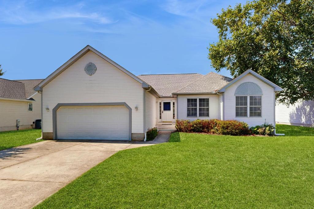 ein weißes Haus mit Garage im Hof in der Unterkunft Maplewood --- 17 Tulane Dr - Ohana House in The Plantations