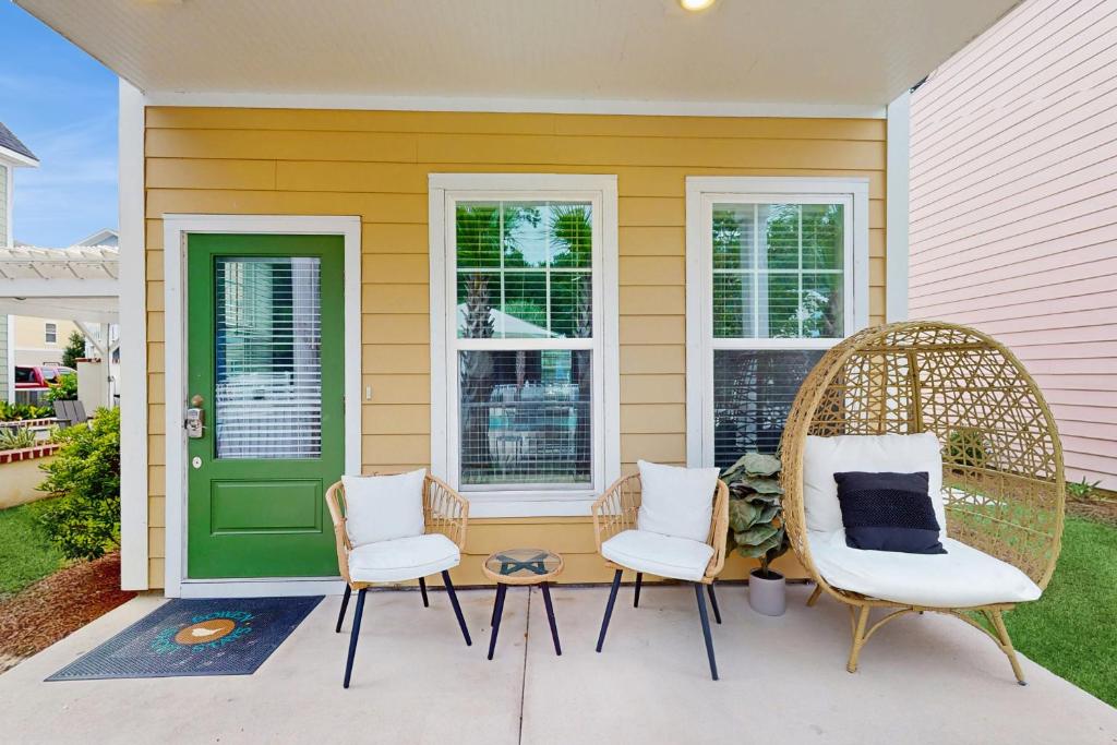 a porch with two chairs and a green door at Bowen Village 6110 in Charleston