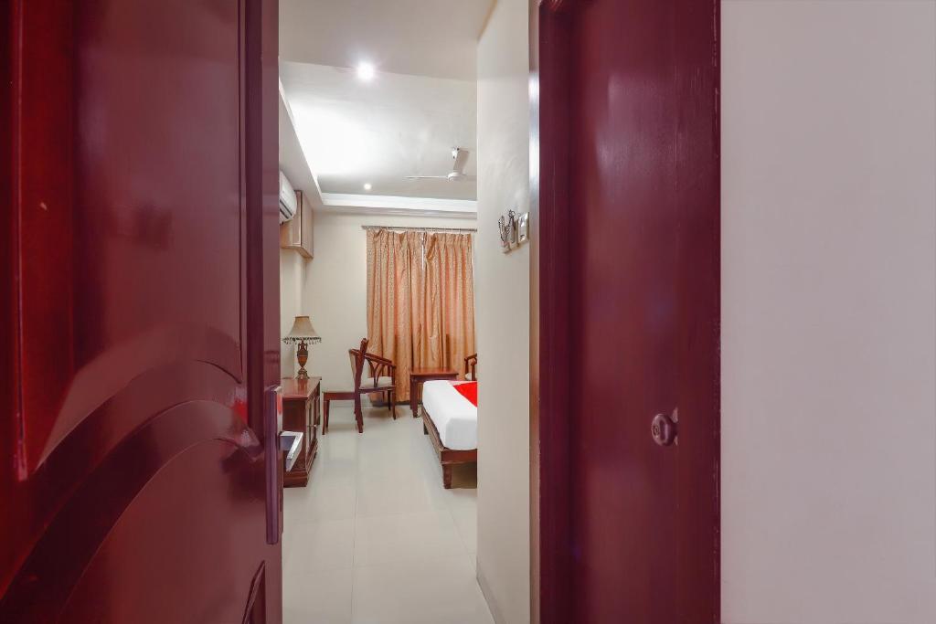 a room with a bedroom with a bed and a door at Hotel O Grandeur By orbit Hotels Near Chennai shopping mall in Hyderabad