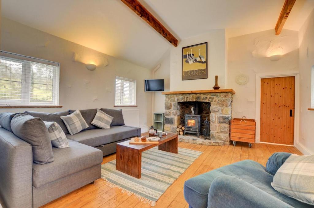 a living room with a couch and a fireplace at Ty Rowan in Trefriw