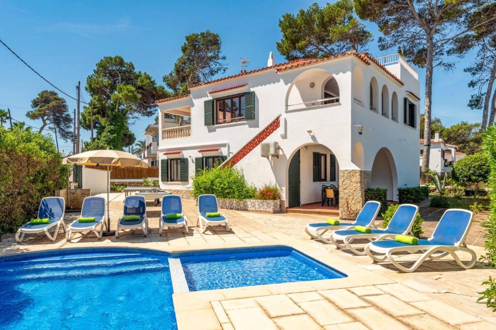 a villa with a swimming pool in front of a house at Villa Gatzara by Villa Plus in Cala Blanca