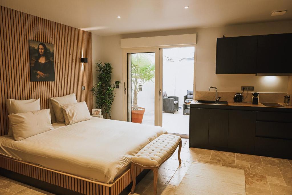 a bedroom with a large bed and a kitchen at Da Mona in Reims