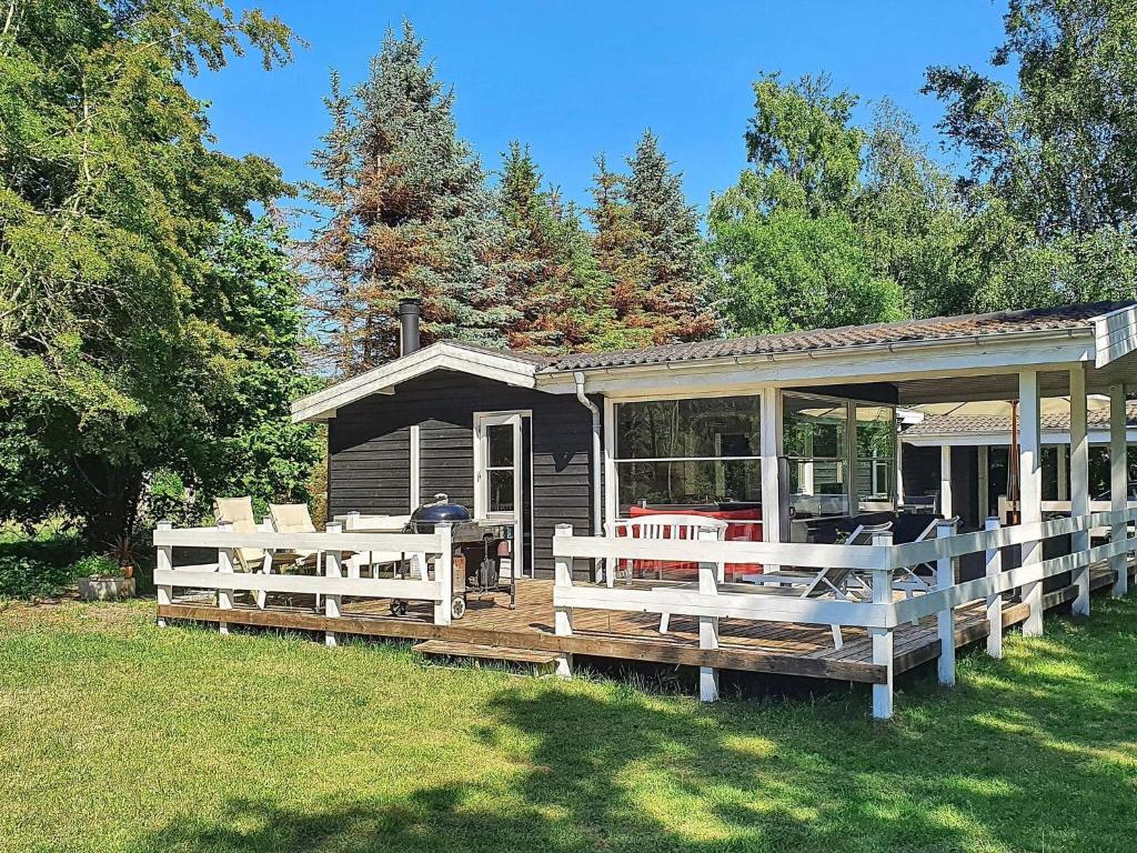 a house with a porch and a deck with chairs at 6 person holiday home in Gørlev in Gørlev