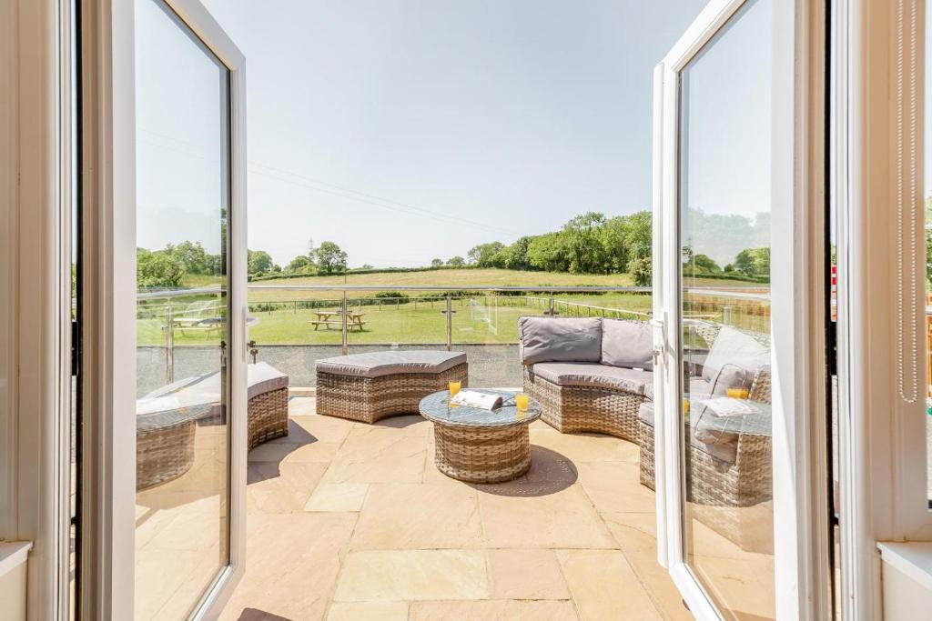 einen Balkon mit einem Sofa und einem Tisch in der Unterkunft Yr Hen Barlwr in Llanddyfnan