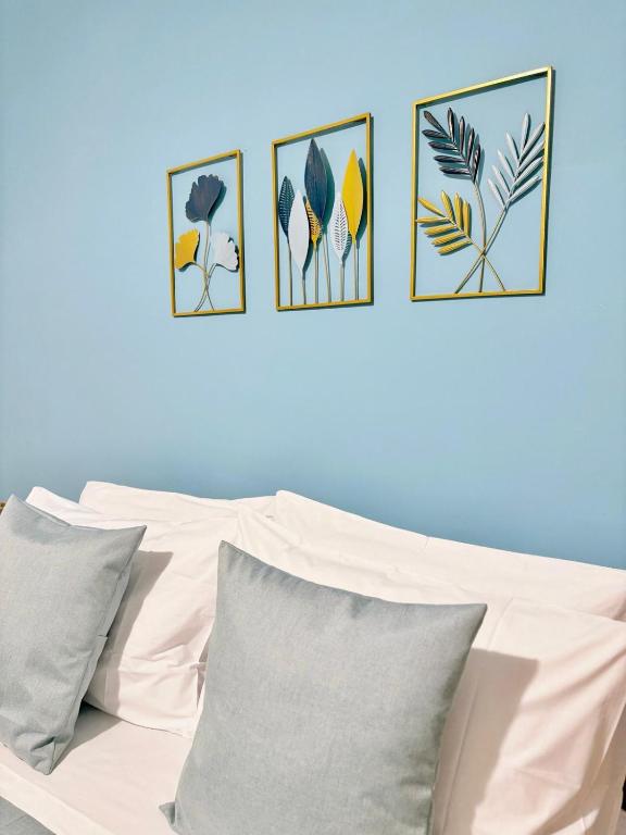 a white couch with four pictures on a blue wall at Deborah's House in Ercolano
