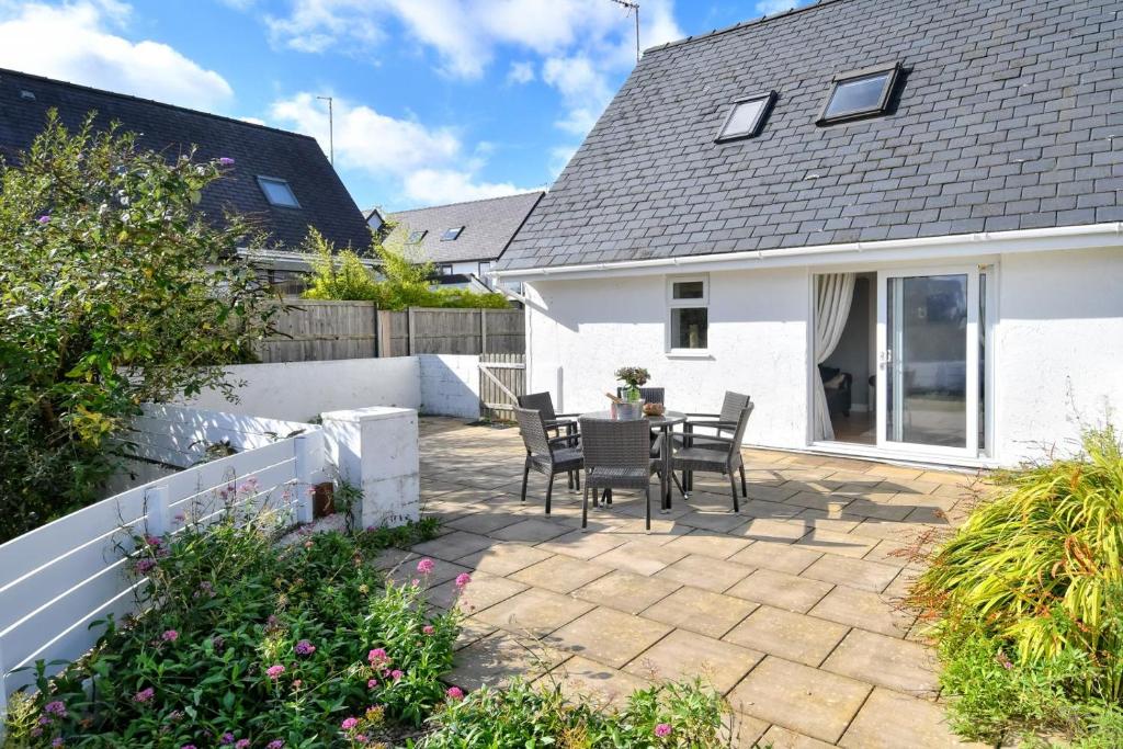 a patio with a table and chairs in a house at 243 Cae Du in Abersoch