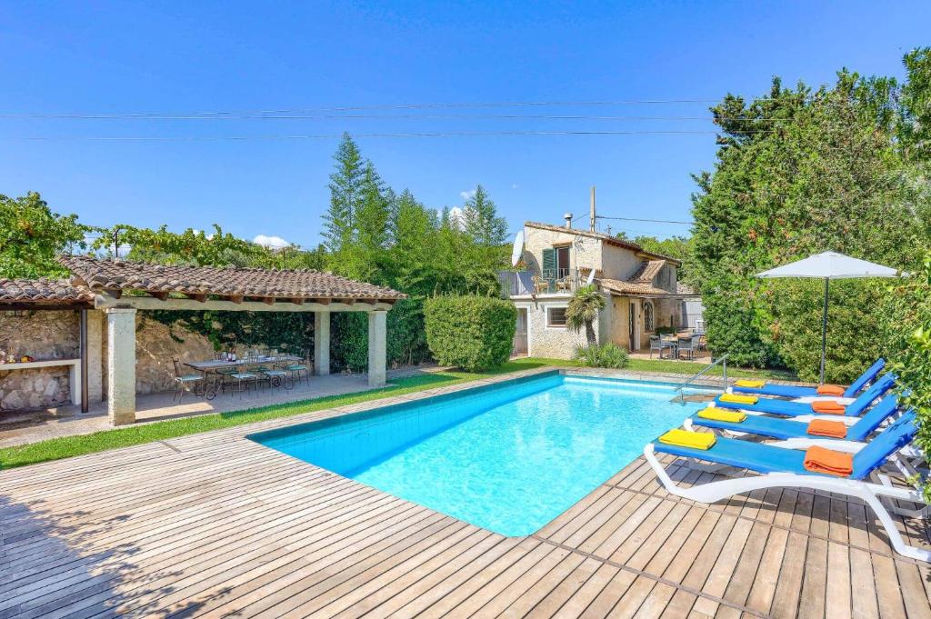 a swimming pool with chairs and an umbrella at Villa Rafaleta by Villa Plus in Pollença