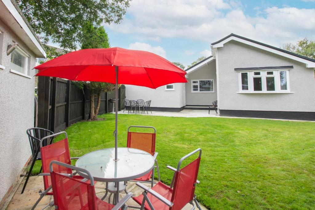 桑德斯富特Ashwood的一张桌子、红色的椅子和红色的雨伞