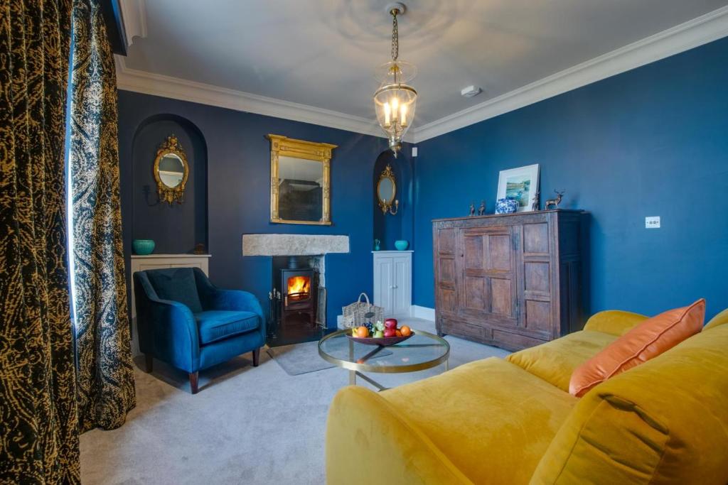 ein Wohnzimmer mit gelber Couch und blauen Wänden in der Unterkunft Orchard Cottage in Newlyn