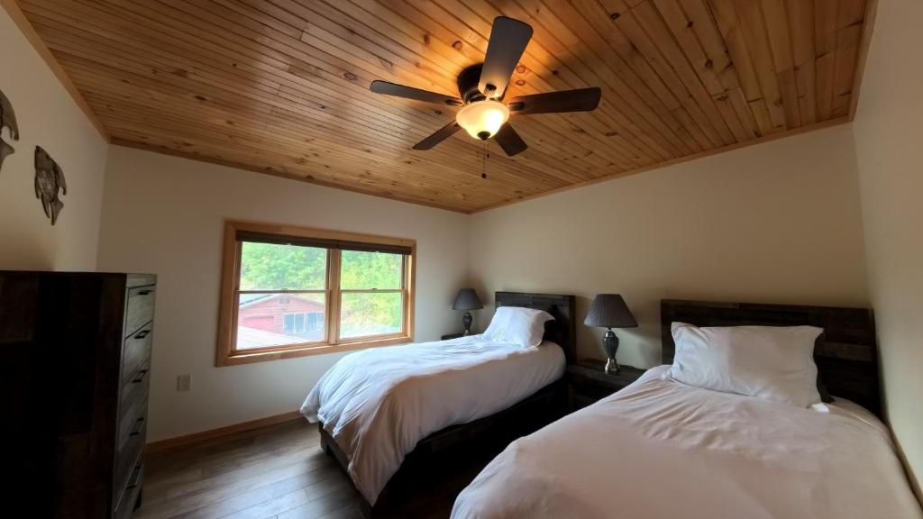een slaapkamer met twee bedden en een plafondventilator bij Modern Lakeview Escape in Hammond