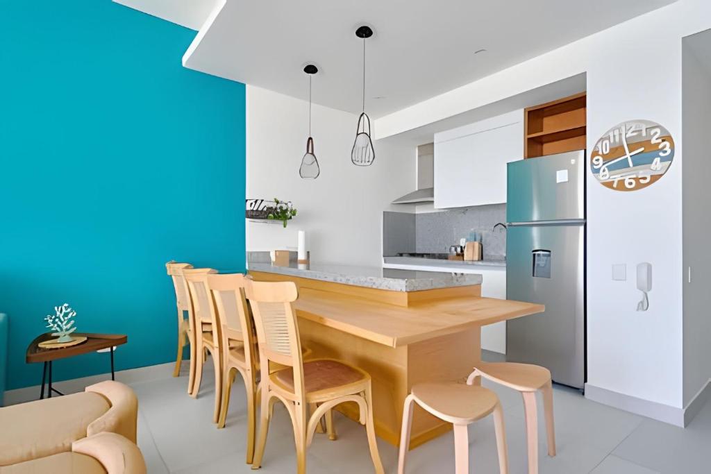 Una cocina con una mesa y sillas de madera. en Caribbean Breeze beachfront apartment, en La Puntica de Juan Dolio