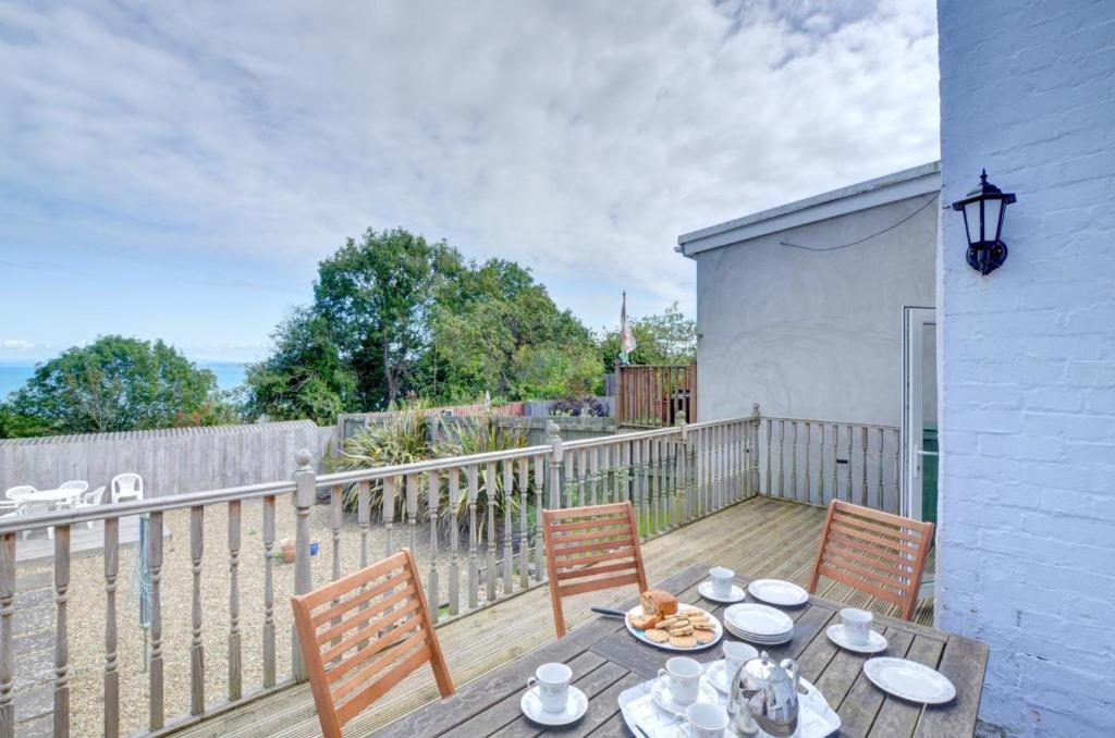 a wooden table with two chairs on a deck at Elvor in New Quay